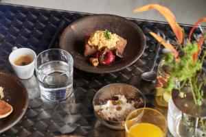 a table with a plate of food and a glass of water at The Newel Acropolis in Athens