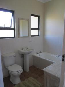 a bathroom with a toilet and a sink and a tub at Sea View in Coffee Bay