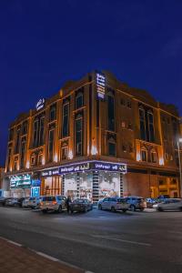 een groot gebouw met auto's geparkeerd voor het bij دانة الشرقية للشقق المخدومة بالدمام Danat Al Sharqiah Serviced Apartments in Dammam