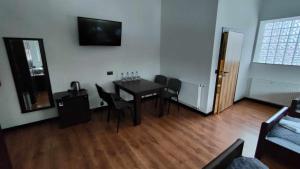 Baza noclegowa Mistral في سيرادز: غرفة مع طاولة وكراسي وتلفزيون على الحائط