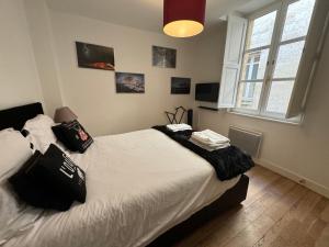 una camera da letto con un letto con cuscini neri sopra di L'annexe Bordeaux Traditions a Bordeaux