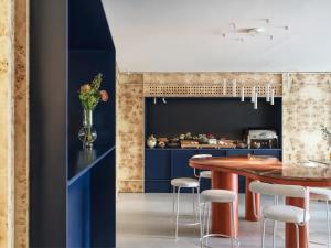 a kitchen with blue cabinets and a table with stools at The Newel Acropolis in Athens