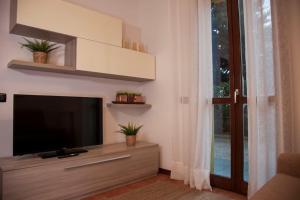 sala de estar con TV de pantalla plana y ventana en [Montecatini Terme] ''Lo Zizzolo'' Casa Moderna e Tranquilla en Montecatini Terme