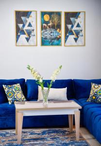 Family Aparthotel في الدار البيضاء: غرفة معيشة مع أريكة زرقاء وطاولة