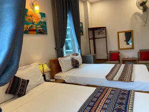 a hotel room with two beds and a window at Tam Coc Green Fields Homestay in Ninh Binh