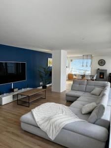 sala de estar con sofá y TV en Spacieux et lumineux 115m2 idéalement situé, en Les Hôpitaux-Neufs