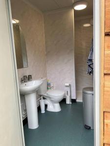 a bathroom with two sinks and a toilet and a mirror at The Peacock Nest - Bell Tent in Sittingbourne