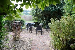 a patio with chairs and a table in a garden at The Peacock Nest - Bell Tent in Sittingbourne