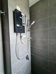 een douche in een badkamer met een televisie aan de muur bij Studio Room near Gleneagles @ Embassy Row KLCC in Kuala Lumpur
