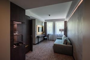 Habitación de hotel con sofá y escritorio en Hotel Azur Premium, en Siófok