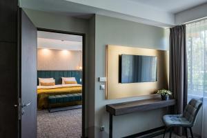 a hotel room with a bed and a mirror at Hotel Azur Premium in Siófok