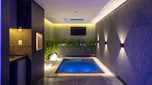 a swimming pool in the middle of a bathroom at Bangalô Motel by Drops in Santa Maria