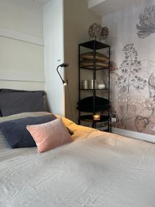 Dormitorio con cama con almohada rosa en Studio Stadshuys053, en Enschede