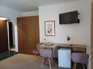 a room with a table and chairs and a tv on the wall at Apartamente Private A&L View in Sinaia
