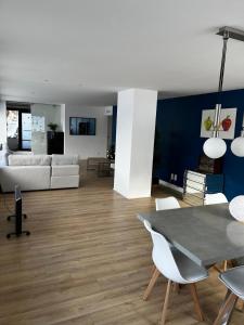 een woonkamer met een bank en een tafel en stoelen bij Spacieux et lumineux 115m2 idéalement situé in Les Hôpitaux-Neufs