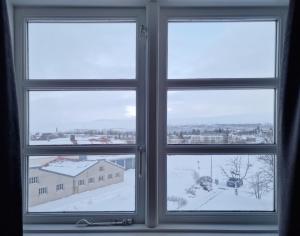a window with a view of a snowy city at Gistihúsið - Lake Hotel Egilsstadir in Egilsstaðir