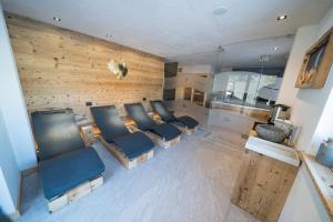 een woonkamer met blauwe stoelen en een houten muur bij Appartamenti da Costantino in Padola