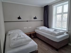 2 camas en una habitación con ventana en Gistihúsið - Lake Hotel Egilsstadir, en Egilsstadir