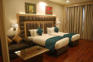a hotel room with a bed and a couch at SK Premium Park, World Square Mall in Ghaziabad +34 photos