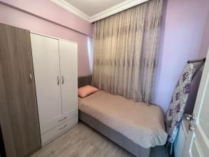 um pequeno quarto com uma cama e uma janela em شقة بإطلالة على الشاطئ والكورنيش 5 Apartment with beach and sea view em Silivri