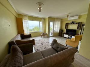 un ampio soggiorno con divano e TV di شقة بإطلالة على الشاطئ والكورنيش 5 Apartment with beach and sea view a Silivri