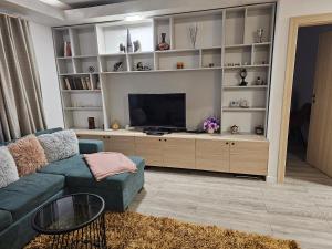 uma sala de estar com um sofá azul e uma TV de tela plana em Nana Apartaments em Cluj-Napoca
