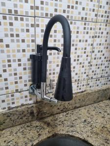 a kitchen sink with a faucet on a counter at Comodidade e Segurança no Centro in Belo Horizonte