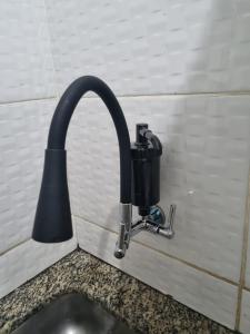 a kitchen sink with a faucet on a wall at Comodidade e Segurança no Centro in Belo Horizonte
