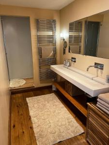 łazienka z dużą umywalką i lustrem w obiekcie Spacieux et lumineux 115m2 idéalement situé w mieście Les Hôpitaux-Neufs