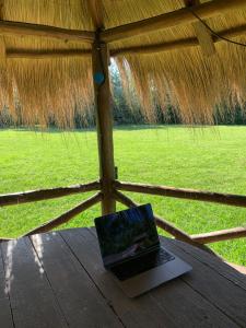 a laptop computer sitting on a table in a straw tent at La Calma Casa Quinta - PISCINA, PARRILLA, WIFI - in Pilar