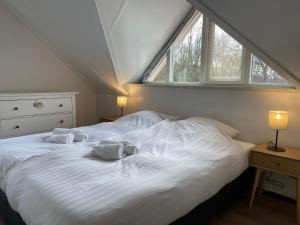 1 dormitorio con 1 cama blanca y 2 almohadas en De Zilverreiger by Droomvilla, en Langweer