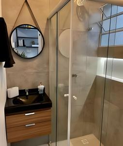 a bathroom with a shower with a sink and a mirror at Studios Tiny House - Viva Essa Experiência in Sao Paulo