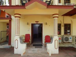 a house with two red chairs on the porch at R mansion in Calangute