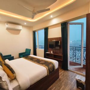 ein Hotelzimmer mit einem Bett und einem Balkon in der Unterkunft Hotel East Wood Amritsar in Amritsar