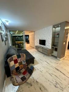 a living room with a couch and a tv at Casa Pampulha - espaço Gourmet com Piscina Aquecida in Belo Horizonte