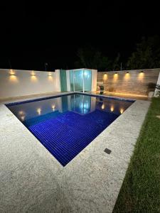 una piscina por la noche con azulejos azules en Casa Pampulha - espaço Gourmet com Piscina Aquecida, en Belo Horizonte
