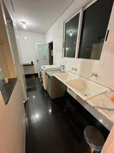a bathroom with two sinks and a large mirror at Casa Pampulha - espaço Gourmet com Piscina Aquecida in Belo Horizonte