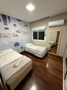 1 dormitorio con 2 camas y una pared con planos en Casa Pampulha - espaço Gourmet com Piscina Aquecida, en Belo Horizonte