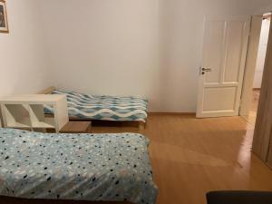 a room with two beds and a table and a door at Wohnung im Rebenring in Braunschweig