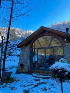 a cabin in the snow with a large window at Zamane evleri in Çamlıhemşin