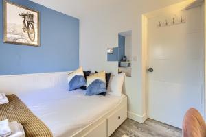 a bedroom with a bed with blue pillows on it at Hackney Central Deluxe Apartment in London