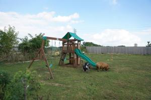 two animals standing in a yard with a playground at Rhea Retreat - Bell Tent in Sittingbourne