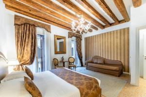 a bedroom with two beds and a couch at San Teodoro Palace - Luxury Apartments in Venice