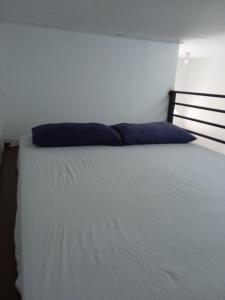 a bed with a blue pillow on top of it at Tiny House Idaman Kuala Terengganu with Private House in Kuala Terengganu