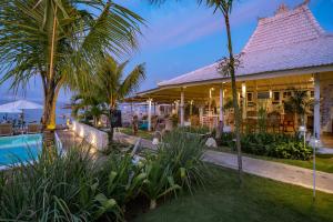 a resort with a swimming pool and palm trees at Paus Putih Hotel in Nusa Lembongan