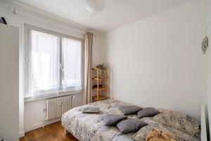 a bedroom with a bed with pillows on it at Lyon Séjour Chambre Cozy pour une personne chez l habitant in Lyon