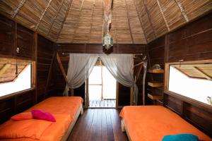 two beds in a room with two windows at Urraca Private Island Bocas del Toro in Buena Vista
