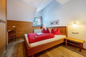 a bedroom with a large bed with red pillows at Lechnerhof Apt 3 in Braies