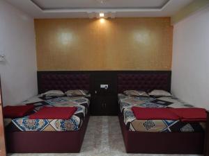 a bedroom with two beds with red pillows at R mansion in Calangute