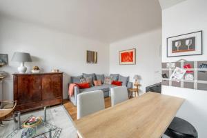 ein Wohnzimmer mit einem Sofa und einem Holztisch in der Unterkunft PARIS 6EME - Studio in Paris